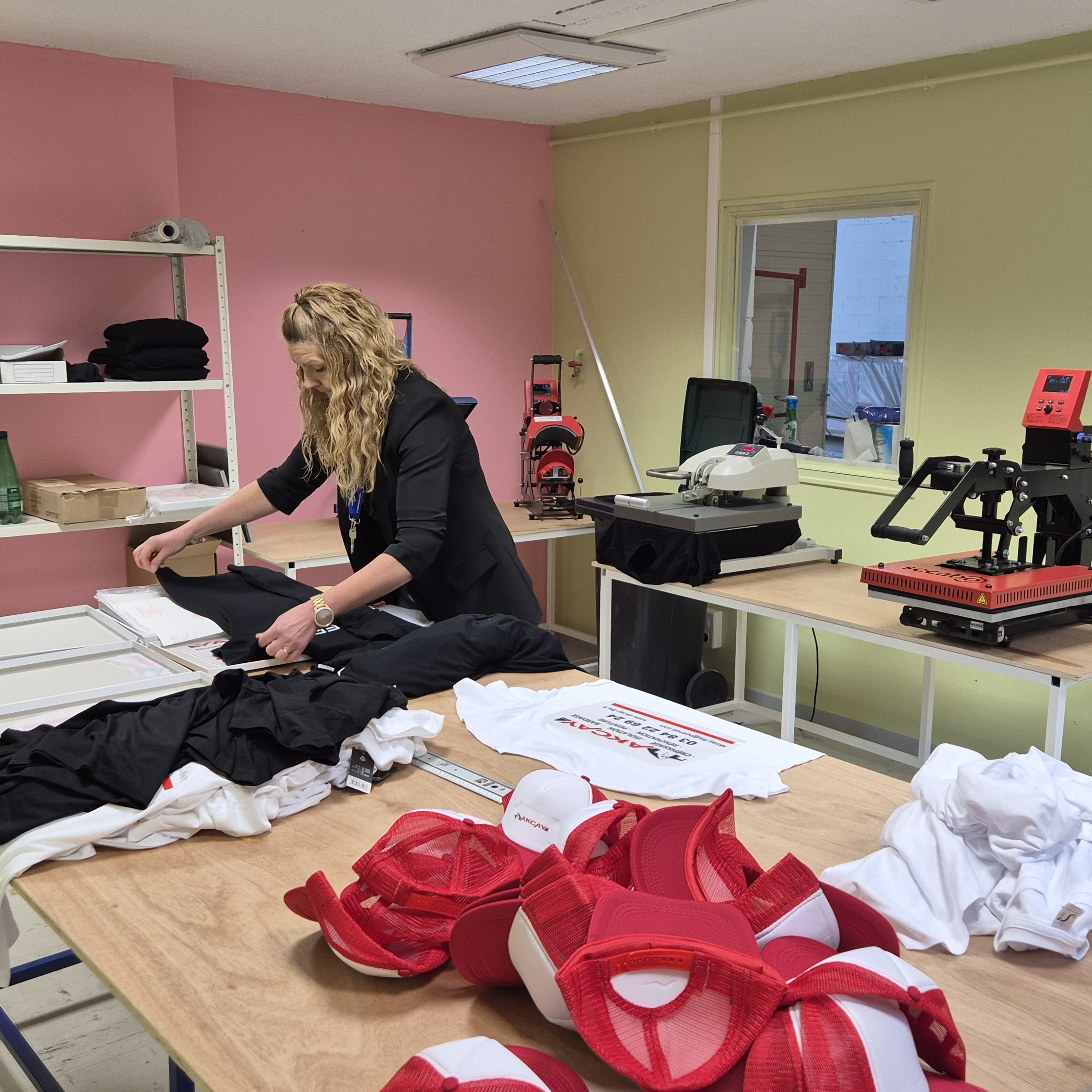 une personne qui travail dans un atelier de flocage de vetement